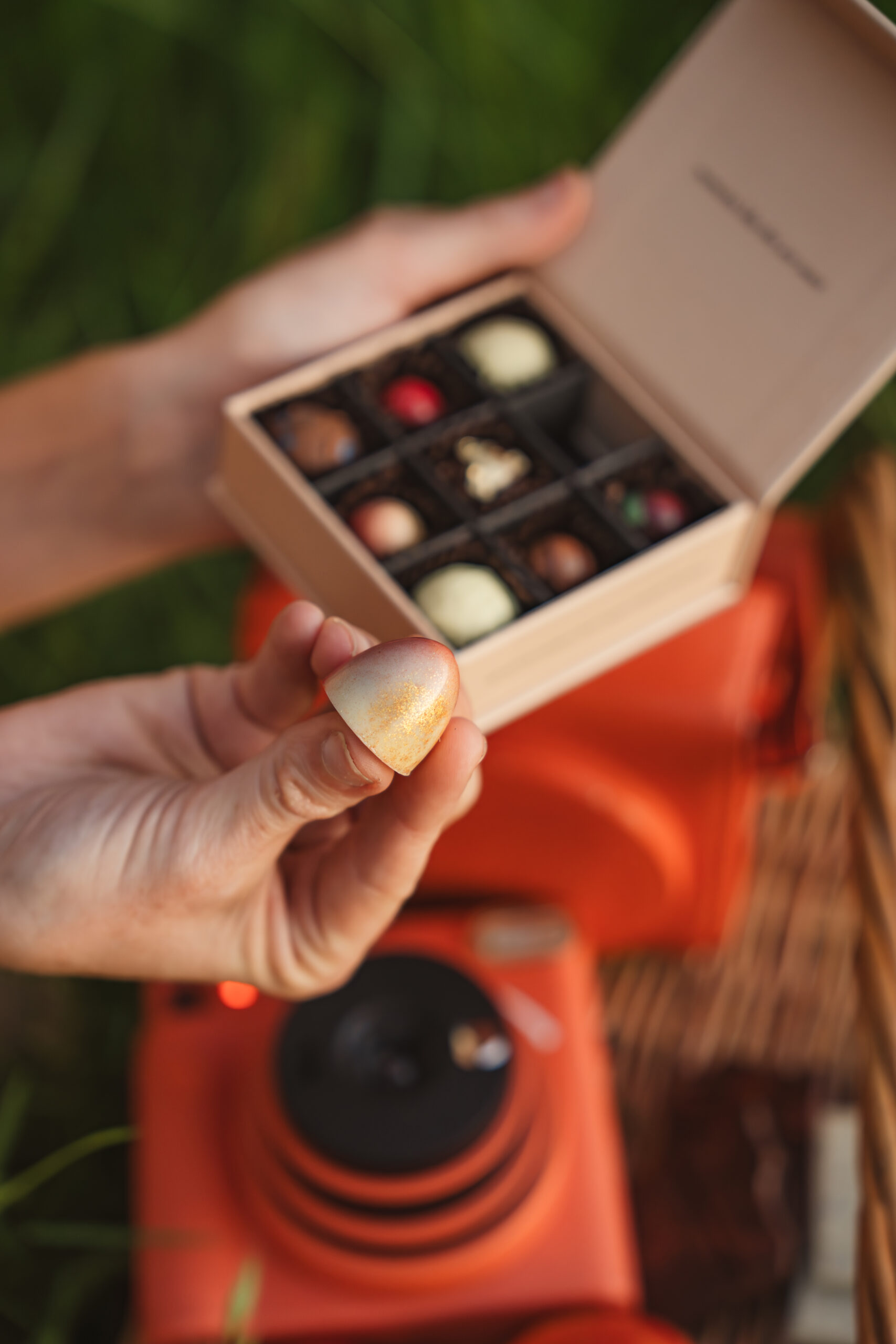 Woman holding MicroDays microdose chocolate bonbon and truffles outdoors.