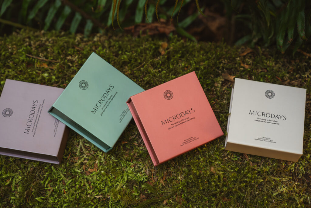 Four MicroDays chocolate boxes arranged on forest moss